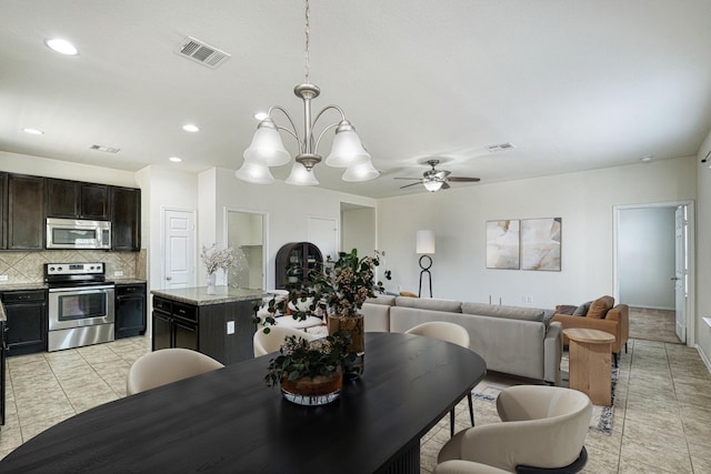 tiled dining room with ceiling fan with notable chandelier