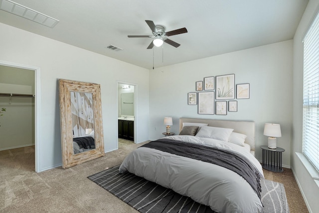 carpeted bedroom featuring ceiling fan, a walk in closet, connected bathroom, and a closet