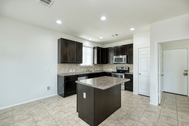 kitchen featuring dark brown cabinetry, sink, stainless steel appliances, and a kitchen island