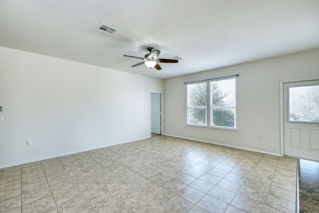 tiled spare room featuring ceiling fan