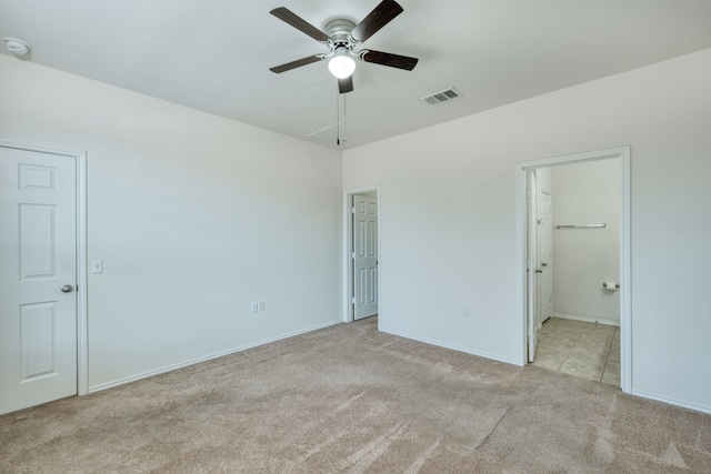 unfurnished bedroom featuring ensuite bathroom, light carpet, and ceiling fan