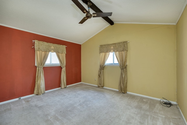 carpeted spare room featuring a healthy amount of sunlight, vaulted ceiling with beams, ceiling fan, and ornamental molding