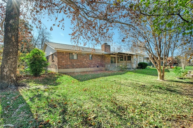 rear view of house with brick siding and a chimney