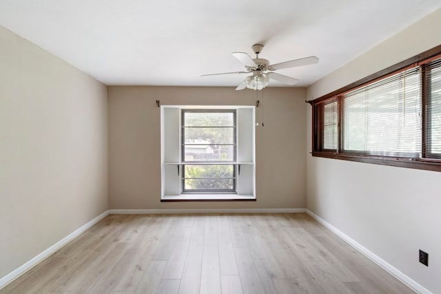 empty room featuring light wood finished floors, ceiling fan, and baseboards