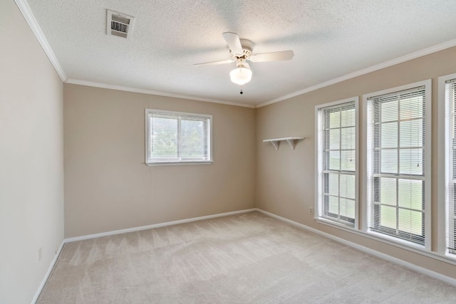 spare room with light carpet, ornamental molding, ceiling fan, baseboards, and a textured ceiling