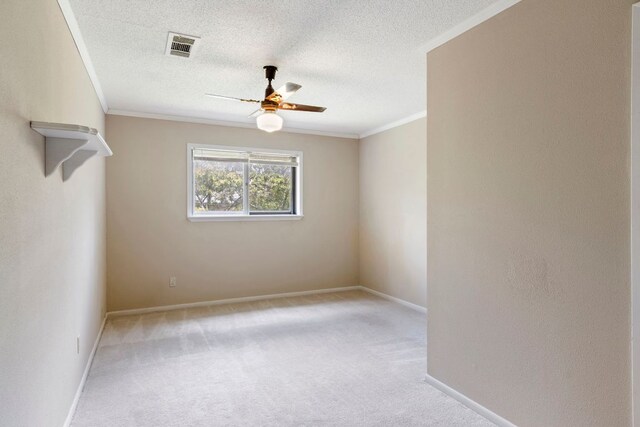 empty room with ceiling fan, ornamental molding, carpet floors, baseboards, and a textured ceiling