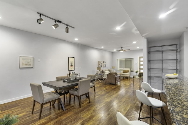 dining area with dark wood-type flooring, track lighting, and ceiling fan