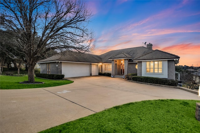 view of front of property with a garage and a lawn