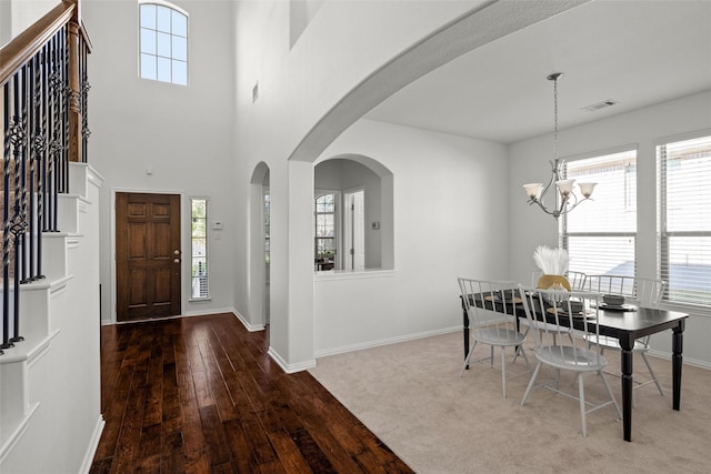 foyer with an inviting chandelier and carpet flooring