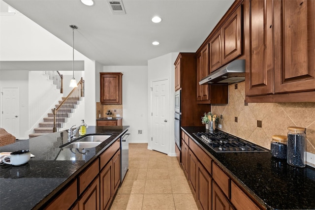 kitchen featuring sink, appliances with stainless steel finishes, hanging light fixtures, light tile patterned flooring, and dark stone counters