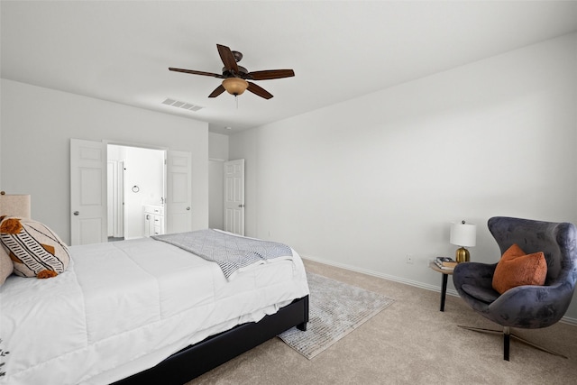 bedroom with carpet floors, ceiling fan, and ensuite bath