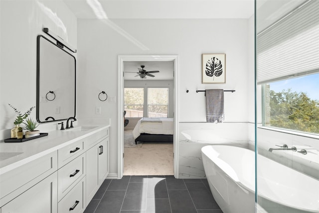 bathroom featuring vanity, a washtub, and tile patterned floors