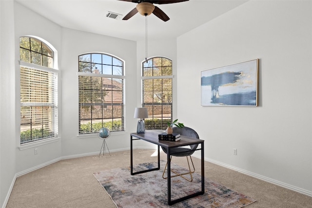 carpeted office space with ceiling fan