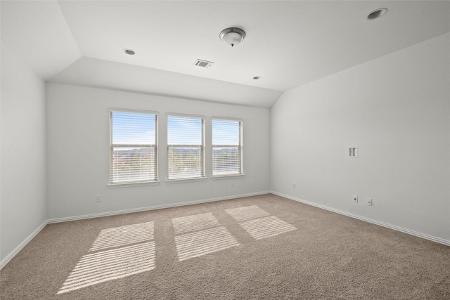 empty room with vaulted ceiling and light carpet