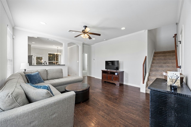 living room featuring ornamental molding, dark hardwood / wood-style floors, and ceiling fan with notable chandelier