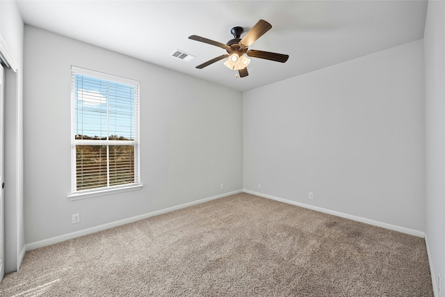 carpeted spare room featuring ceiling fan