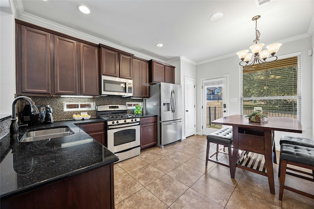 kitchen with appliances with stainless steel finishes, sink, hanging light fixtures, light tile patterned floors, and crown molding