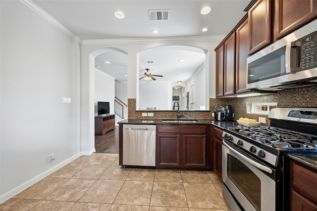 kitchen featuring light tile patterned flooring, sink, crown molding, tasteful backsplash, and appliances with stainless steel finishes