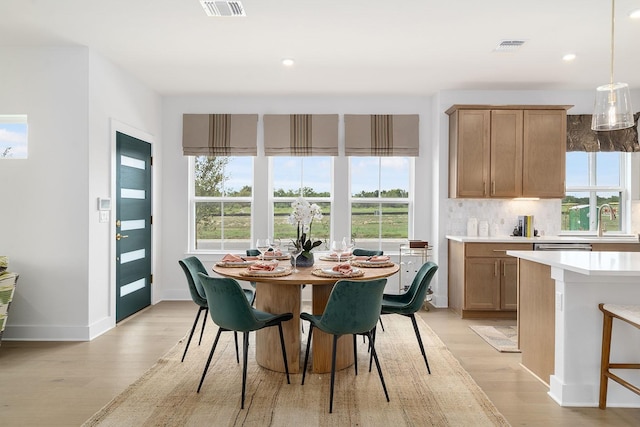 dining space with sink and light hardwood / wood-style floors