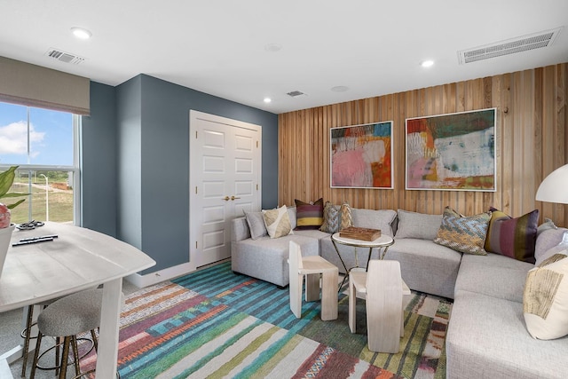 living room with dark carpet and wooden walls