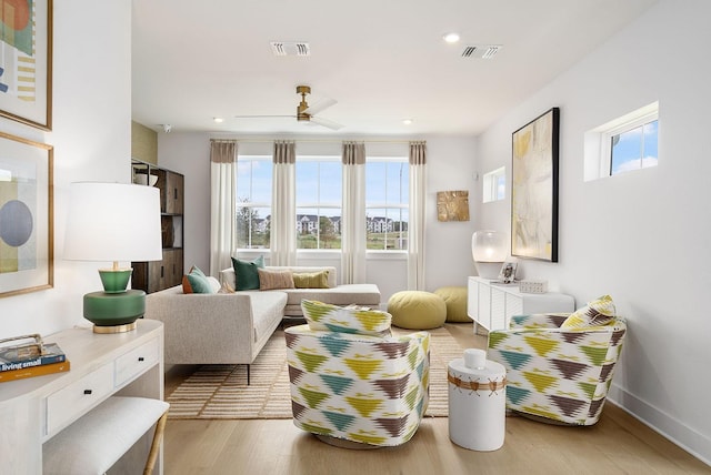 living area featuring ceiling fan and light hardwood / wood-style floors