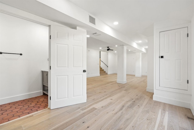 basement featuring ceiling fan and light wood-type flooring