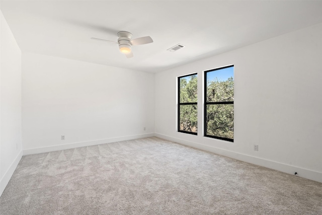 empty room with ceiling fan and light carpet