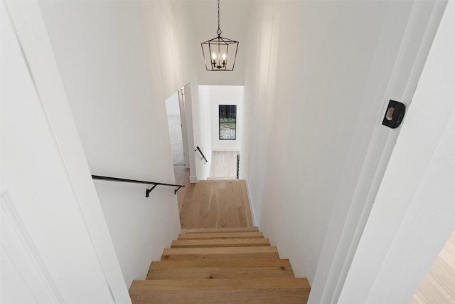 stairway featuring a chandelier