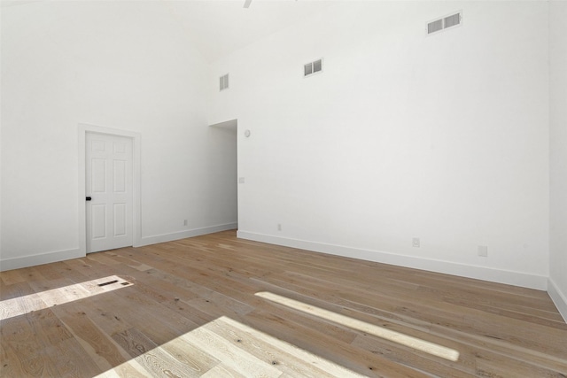 unfurnished room with light hardwood / wood-style floors and a high ceiling