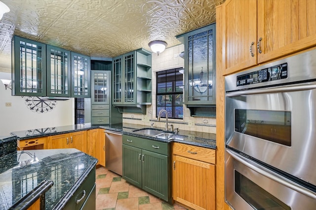 kitchen with stainless steel appliances, sink, and dark stone countertops