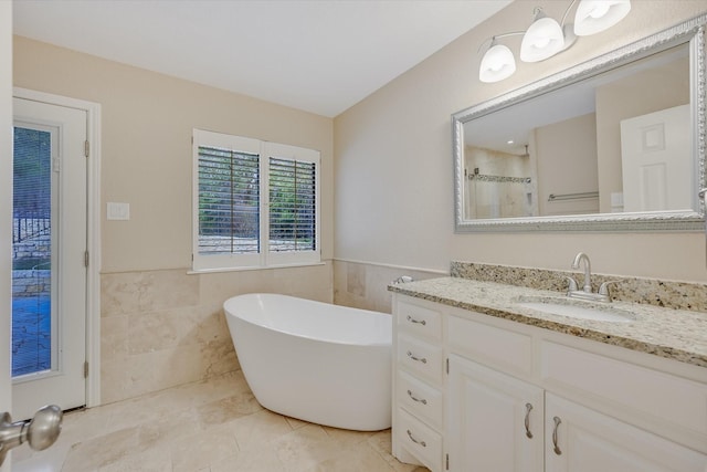 bathroom featuring vanity, plus walk in shower, and tile walls