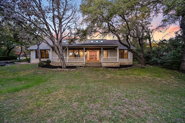 view of front of home with a porch and a lawn