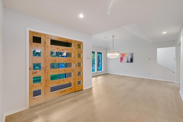 spare room with a chandelier and light hardwood / wood-style floors