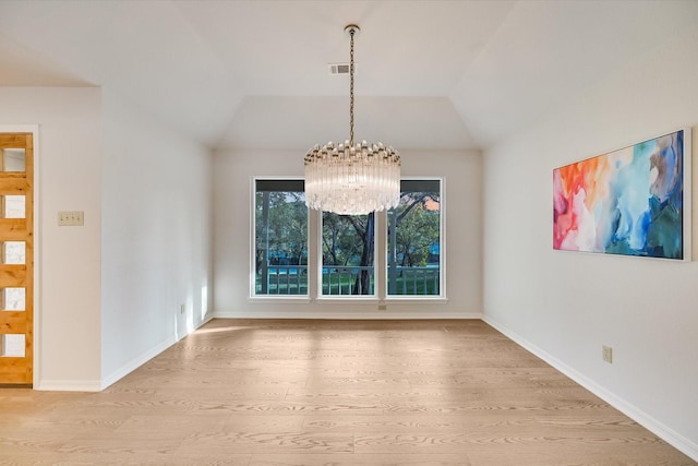 unfurnished dining area with vaulted ceiling, light wood-type flooring, and a chandelier