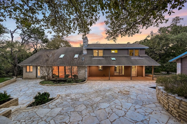 back house at dusk with a patio