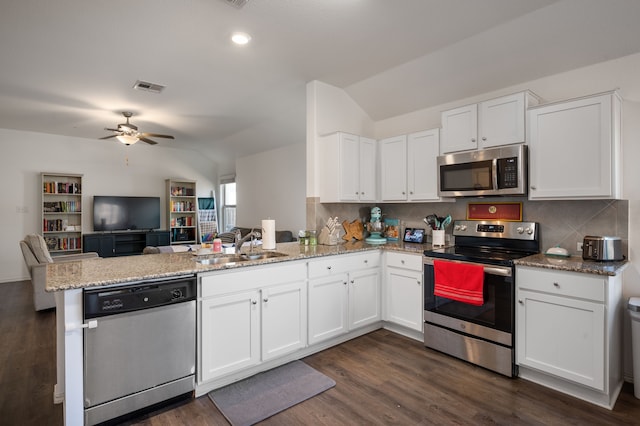 kitchen with appliances with stainless steel finishes, tasteful backsplash, sink, white cabinets, and kitchen peninsula