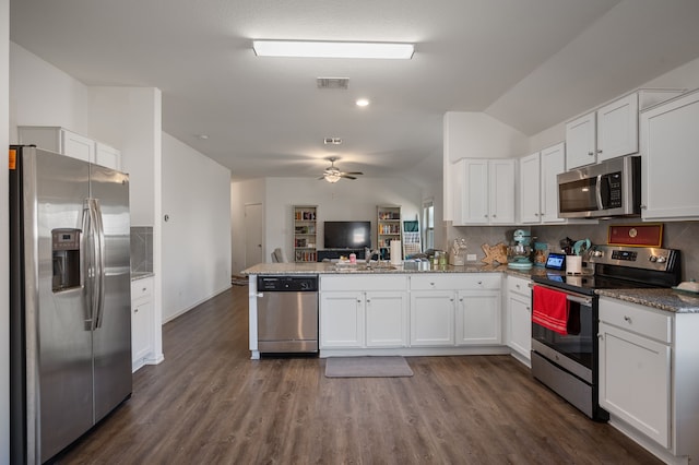 kitchen featuring stone counters, white cabinetry, lofted ceiling, kitchen peninsula, and stainless steel appliances