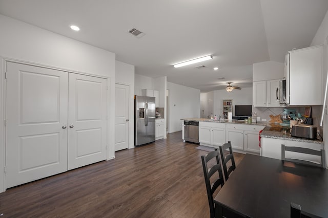 kitchen featuring ceiling fan, white cabinetry, stainless steel appliances, decorative backsplash, and kitchen peninsula