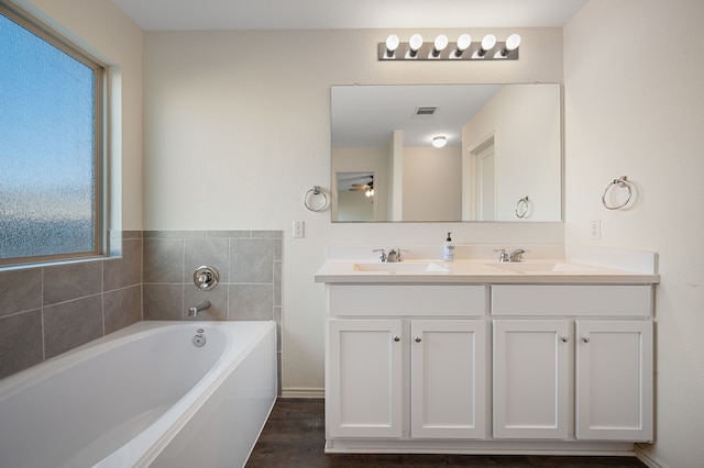 bathroom featuring hardwood / wood-style floors, vanity, a tub, and a wealth of natural light