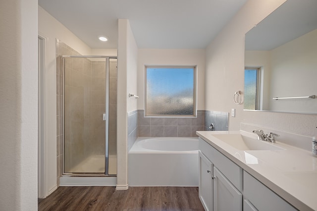 bathroom featuring vanity, wood-type flooring, and shower with separate bathtub