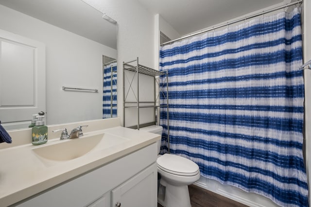 bathroom with walk in shower, toilet, a textured ceiling, vanity, and hardwood / wood-style flooring