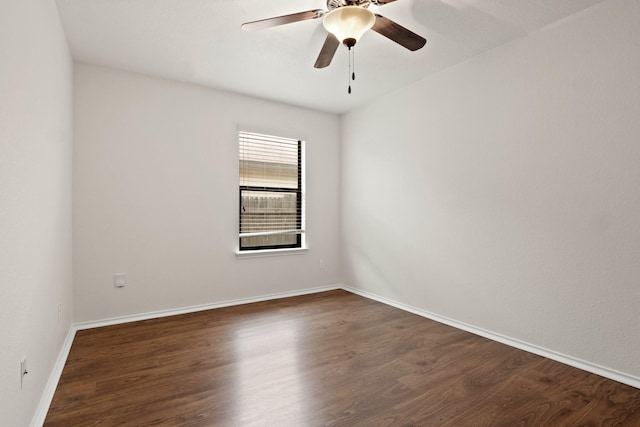 spare room with dark hardwood / wood-style flooring and ceiling fan