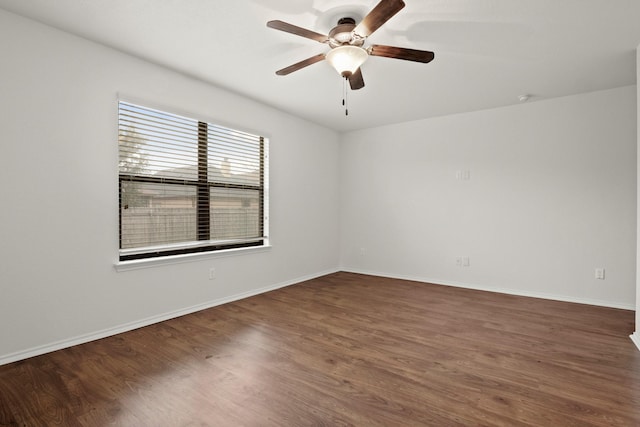 spare room with dark wood-type flooring and ceiling fan