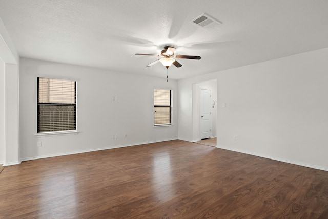 unfurnished room featuring dark wood-type flooring, a textured ceiling, and ceiling fan