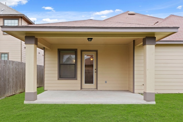 doorway to property with a patio and a lawn