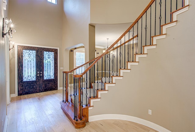 entrance foyer featuring a wealth of natural light, light hardwood / wood-style floors, and a high ceiling