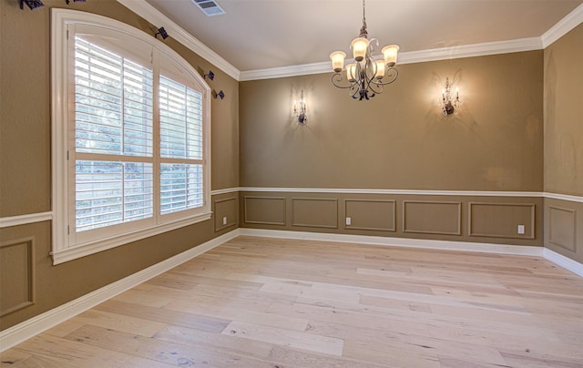 unfurnished dining area with crown molding, a chandelier, and light hardwood / wood-style flooring