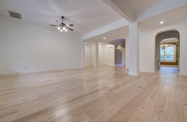 empty room with ceiling fan with notable chandelier, beam ceiling, and light hardwood / wood-style floors