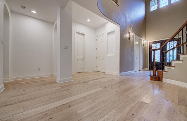 foyer entrance featuring light hardwood / wood-style floors and a high ceiling