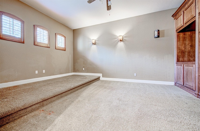 carpeted spare room featuring ceiling fan